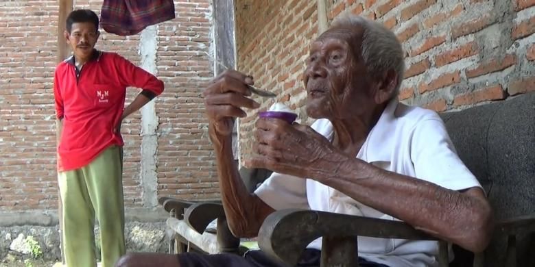 Suparman Sodimedjo atau Mbah Gotho tengah memakan es krim di rumahnya di Klaten, Jawa Tengah, Senin (29/8/2016).