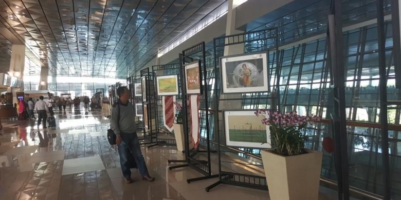 Calon penumpang melihat hasil karya di pameran foto dekat area kedatangan Terminal 3 New Bandara Soekarno-Hatta, Tangerang, Rabu (31/8/2016). 