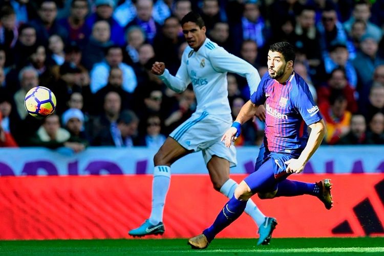 Striker FC Barcelona, Luis Suarez (kanan), berduel dengan bek Real Madrid, Raphael Varane, dalam laga Liga Spanyol di Stadion Santiago Bernabeu, Madrid, pada 23 Desember 2017.