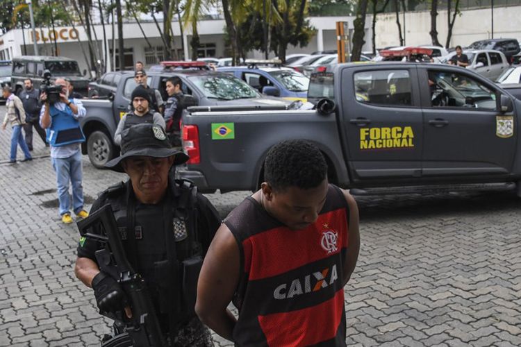 Personel Angkatan Darat tiba di kompleks polisi Cidade da Policia membawa seorang pria yang ditangkap saat melakukan aktivitas perdagangan narkoba di Favela Jacarezinho di Rio de Janeiro, Brasil, pada 21 Agustus 2017.