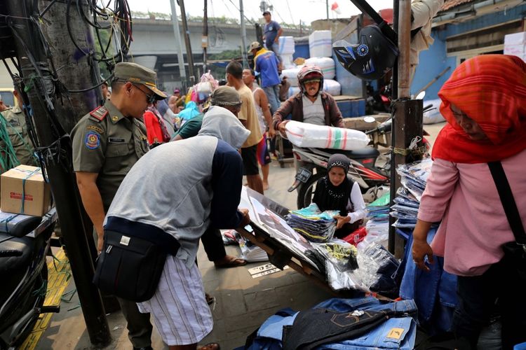 Petugas Satpol PP melakukan penertiban pedagang kaki lima (PKL) yang berjualan di Kawasan Pasar Tanah Abang, Jakarta, Rabu (17/5/2017). Penertiban dilakukan setiap hari menyusul mulai banyaknya PKL yang berjualan di trotoar dan jalan kawasan Pasar Tanah Abang.
