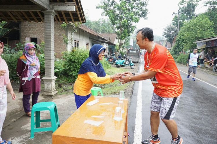 Ibu Siti Waliqah saat membagikan air mineral ke peserta Bank Jateng Borobudur Marathon 2017 secara gratis.