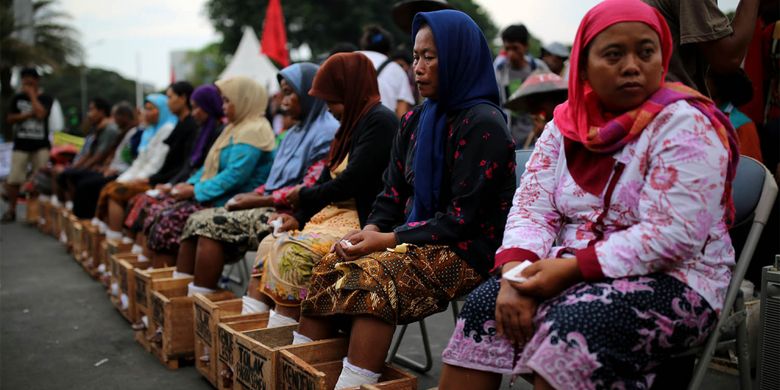 Patmi berkerudung biru (48 tahun) salah seorang petani perempuan asal kawasan Pegunungan Kendeng yang melakukan aksi mengecor kaki di depan Istana Negara, Jakarta, meninggal dunia pada Selasa (21/3/2017) dini hari. Patmi mengalami serangan jantung dan meninggal dalam perjalanan dari kantor LBH Jakarta menuju Rumah Sakit St. Carolus, Salemba, Jakarta Pusat.