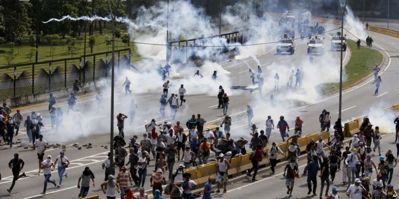 Pasukan keamanan menembakkan gas air mata ke arah demonstran anti-pemerintah di Caracas, Venezuela, Rabu (19/4/2017). Awalnya unjuk rasa damai, lalu rusuh sehingga tiga orang tewas hari itu.