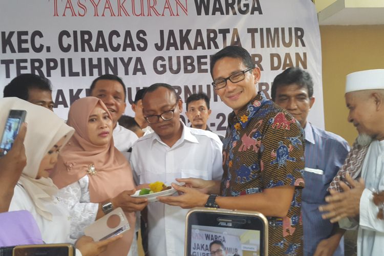 Calon wakil gubernur DKI Jakarta Sandiaga Uno (kanan) bersama sekretaris tim Anies Baswedan-Sandi, Syarif (tengah) memotong tumpeng untuk merayakan kemenangan mereka berdasarkan hasil real count KPU DKI Jakarta di Kelapa Dua Wetan, Ciracas, Jakarta Timur, Senin (24/4/2017).