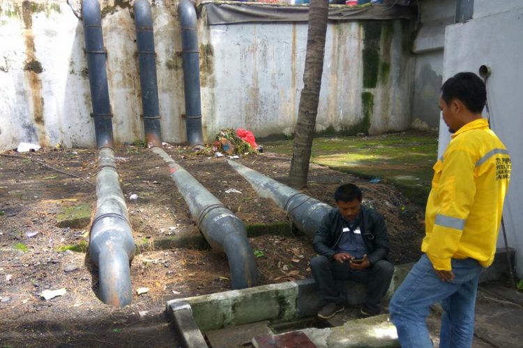 Petugas penjaga Rumah Pompa Dukuh Atas sedang melihat mesin pompa yang sudah kembali berfungsi normal, Selasa (12/12/2017). ((KOMPAS.com/IWAN SUPRIYATNA))