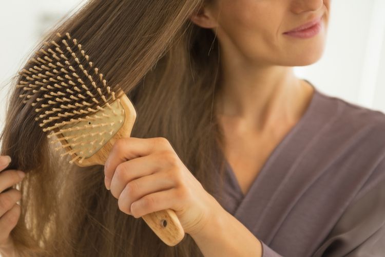 Closeup on young woman combing hair
