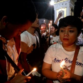 Dua warga saat mengikuti aksi menyalakan lilin di Tugu Yogyakarta, memberikan dukungan untuk Ahok.