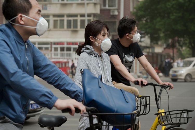 Warga menggunakan masker untuk melindungi diri dari kualitas udara yang buruk akibat badai pasir di Beijing, China, Kamis (4/5/2017). Badai pasir menerjang sebagian besar wilayah China Utara termasuk Beijing yang menyebabkan angin dipenuhi debu dan menghalangi daya pandang.