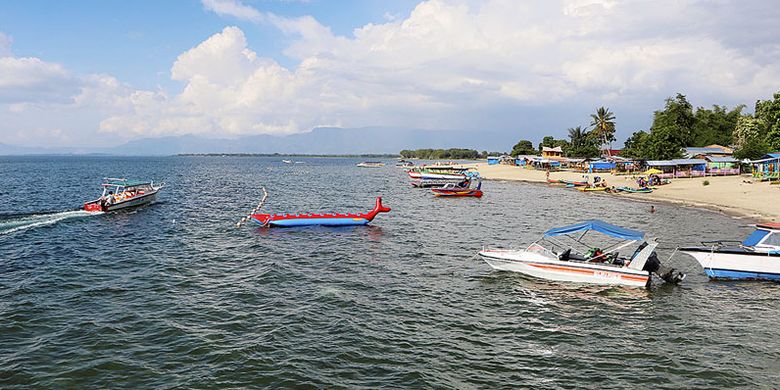 Wisatawan menikmati Danau Toba di Pantai Pasir Putih Lumban Bulbul, Kecamatan Balige, Kabupaten Toba Samosir, Sumatera Utara, Jumat (9/6/2017).(KOMPAS/NIKSON SINAGA)
