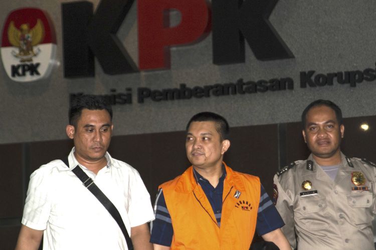 Anggota DPR Komisi XI dari Fraksi Partai Golkar Aditya Moha (tengah) berjalan keluar menggunakan rompi tahanan usai diperiksa di gedung KPK, Jakarta, Minggu (8/10) dini hari. KPK melakukan penahanan usai operasi tangkap tangan (OTT) terhadap Ketua Pengadilan Tinggi Manado Sudiwardono dan Anggota DPR Komisi XI dari Fraksi Partai Golkar Aditya Moha atas kasus dugaan suap hakim untuk mengamankan putusan banding Marlina Moha yang merupakan ibu dari Aditya Moha. ANTARA FOTO/Rosa Panggabean/wsj/17.