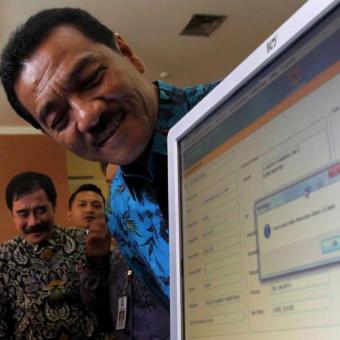 Menteri Dalam Negeri Gamawan Fauzi melihat data e-KTP (KTP elektronik) miliknya yang diperoleh dari hasil pemindaian iris mata di Kementerian Dalam Negeri, Jakarta Pusat, Kamis (8/11/2012). Mendagri menyatakan telah berhasil memenuhi target perekaman e-KTP dengan target 172.015.400 wajib KTP lebih cepat 55 hari daripada tenggat waktu yang ditentukan yaitu 31 Desember 2012.| Kompas.com