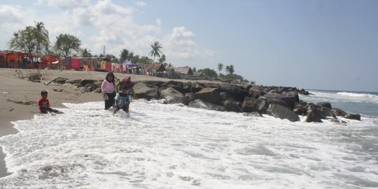 Pengunjung berjalan di pantai Ujong Blang, Banda Sakti, Lhokseumawe, Aceh, Minggu (12/2/2017). 