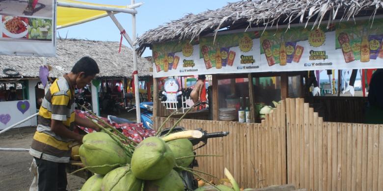 Pekerja mengupas kelapa muda di Pantai Ujong Blang Lhokseumawe, Aceh, Minggu (12/2/2017). 